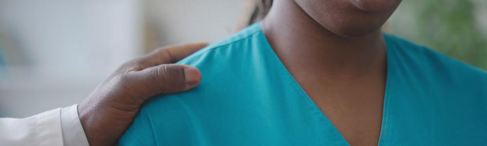 Medical professional with hand on her shoulder