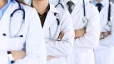 A row of doctors in white coats. Their faces cannot be seen.