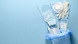 A bag of medical equipment spills out onto a blue background. It includes a mask, gloves, and a syringe.