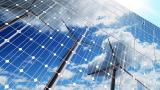 Wind turbines reflected in solar panels.