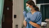 A nurse puts on gloves.