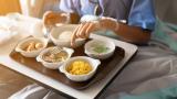 Person eating a meal in a hospital bed.