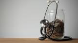 Stethoscope and coins in a glass jar.