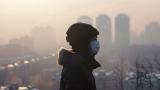 Person wearing mask in front of polluted city