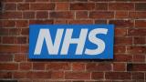NHS logo on brick wall