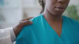 Medical professional with hand on her shoulder