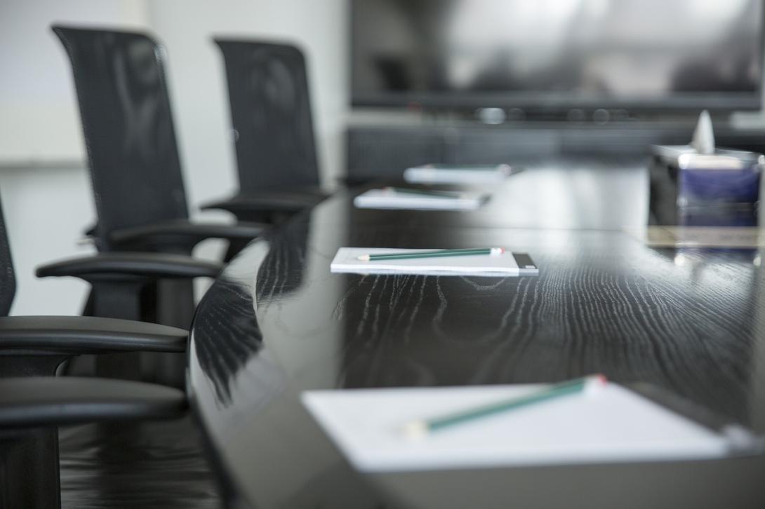 A meeting room, with chairs and a table with notepads
