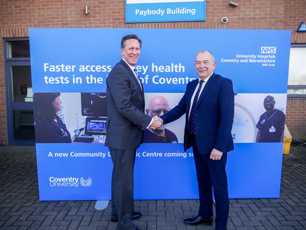 An image of two men shaking hands in front an NHS Coventry sign.