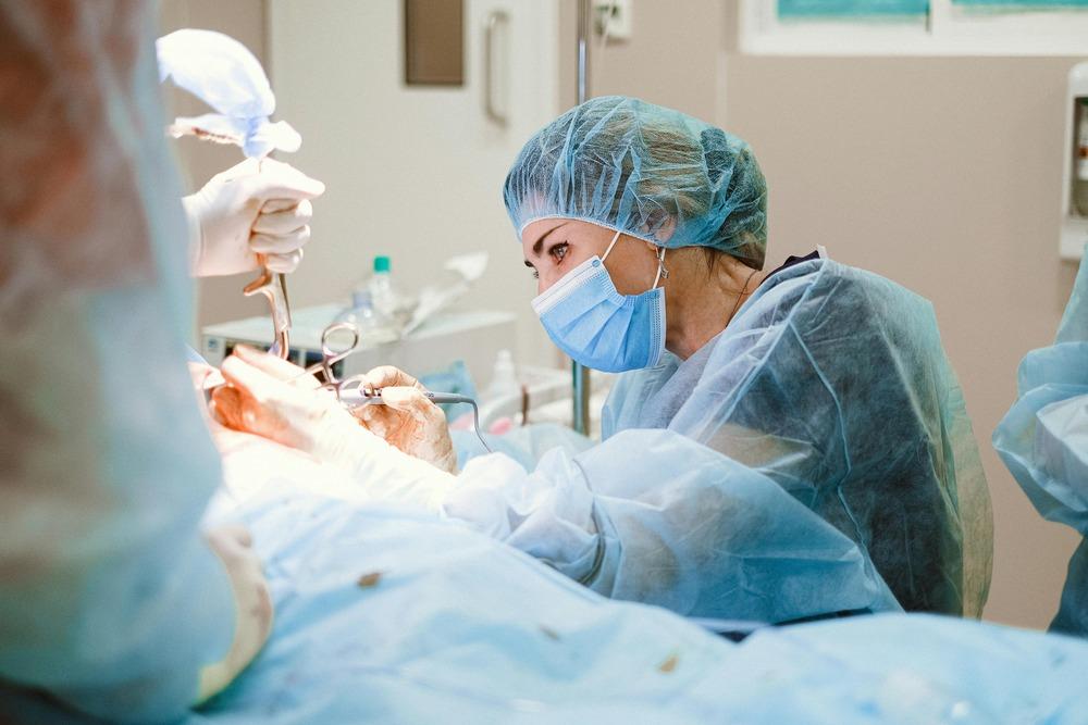 A doctor wearing a surgery hat performs surgery.