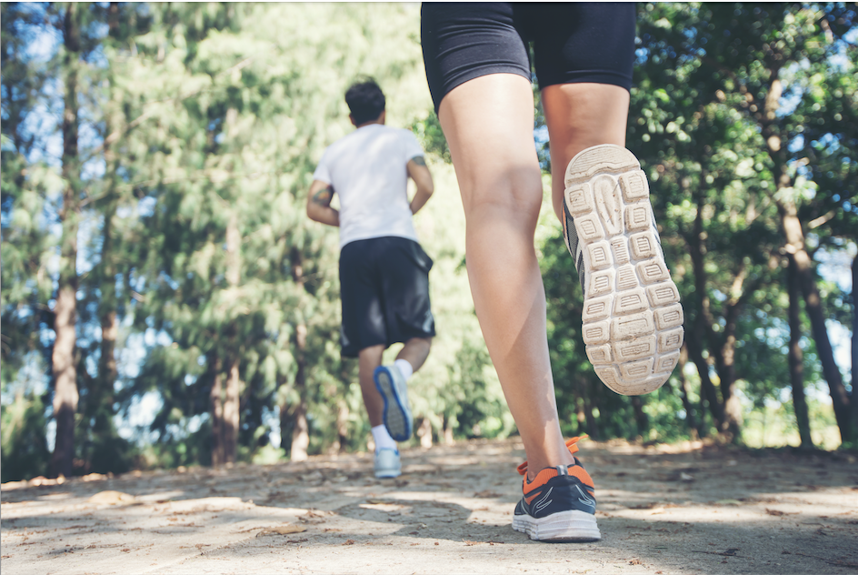 Two people running in the forest