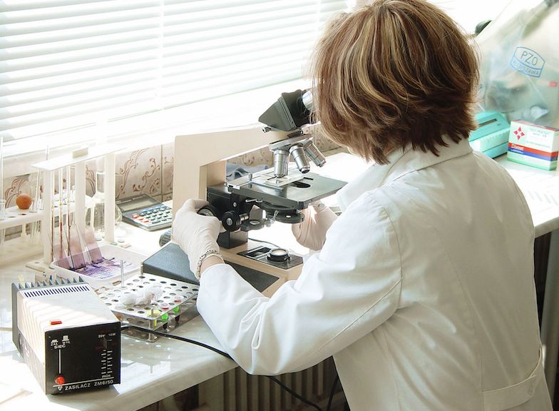 A researcher with a microscope