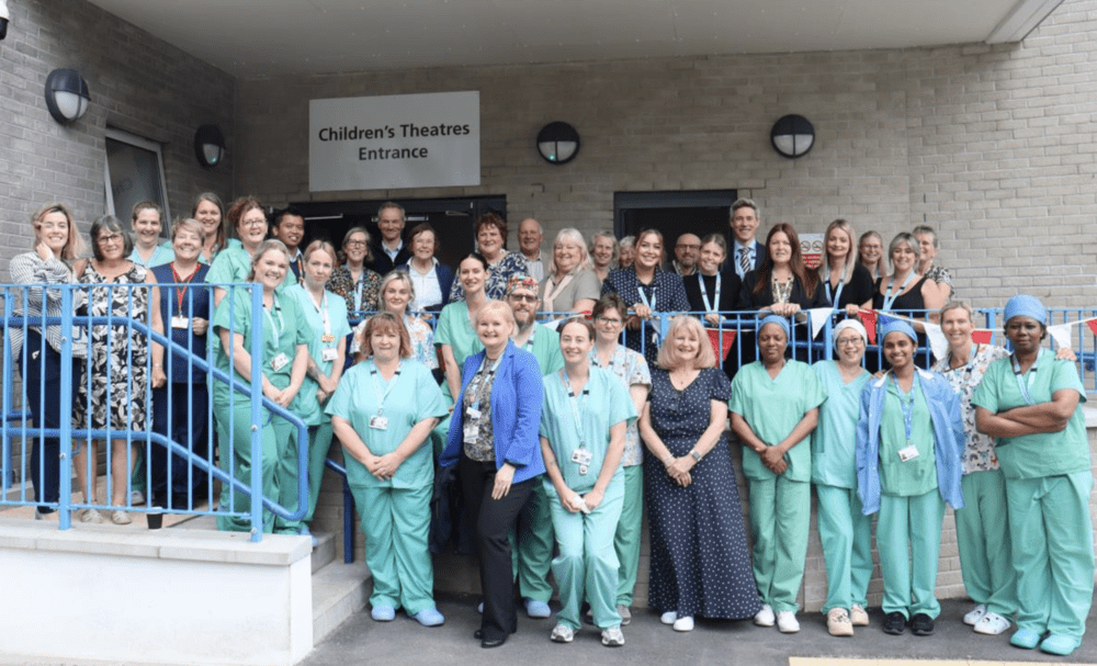 A row of medical staff in blue scrubs standing outside the new surgery unit.