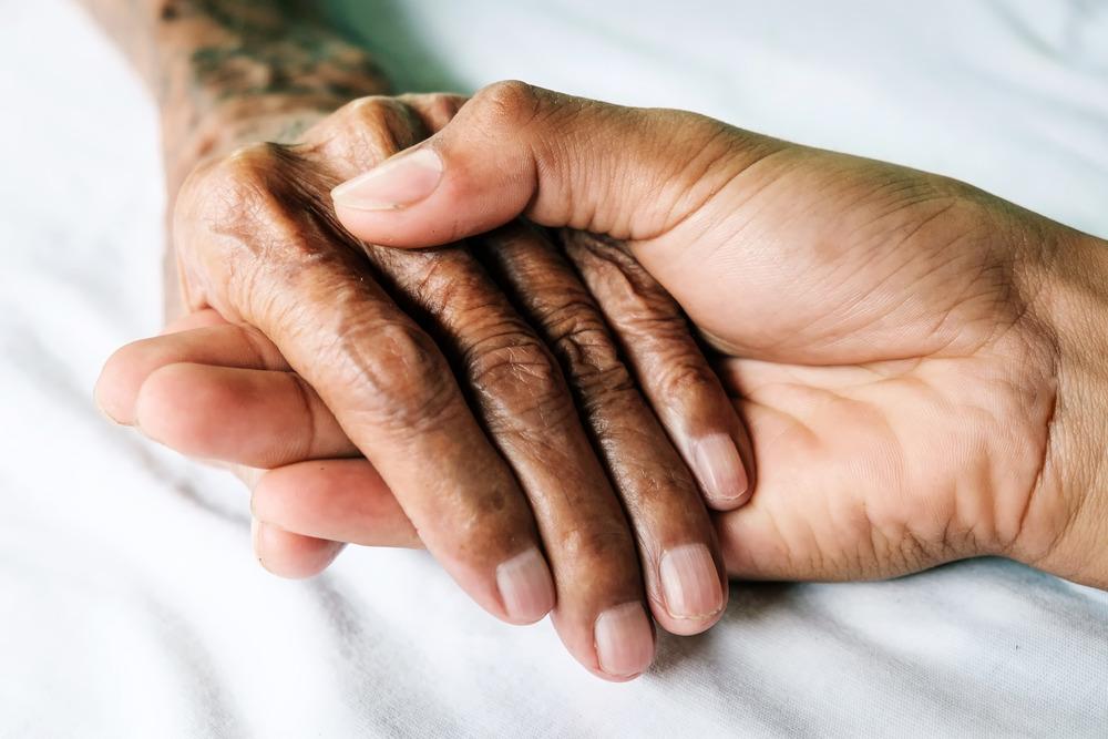 Old person holding hands with younger person.