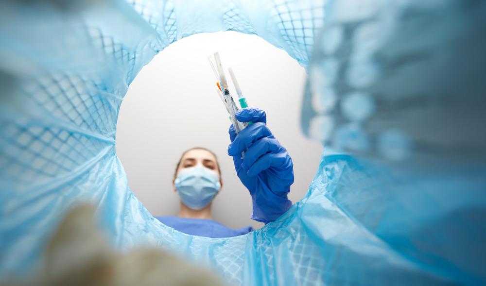 A needle being disposed of in a bin.