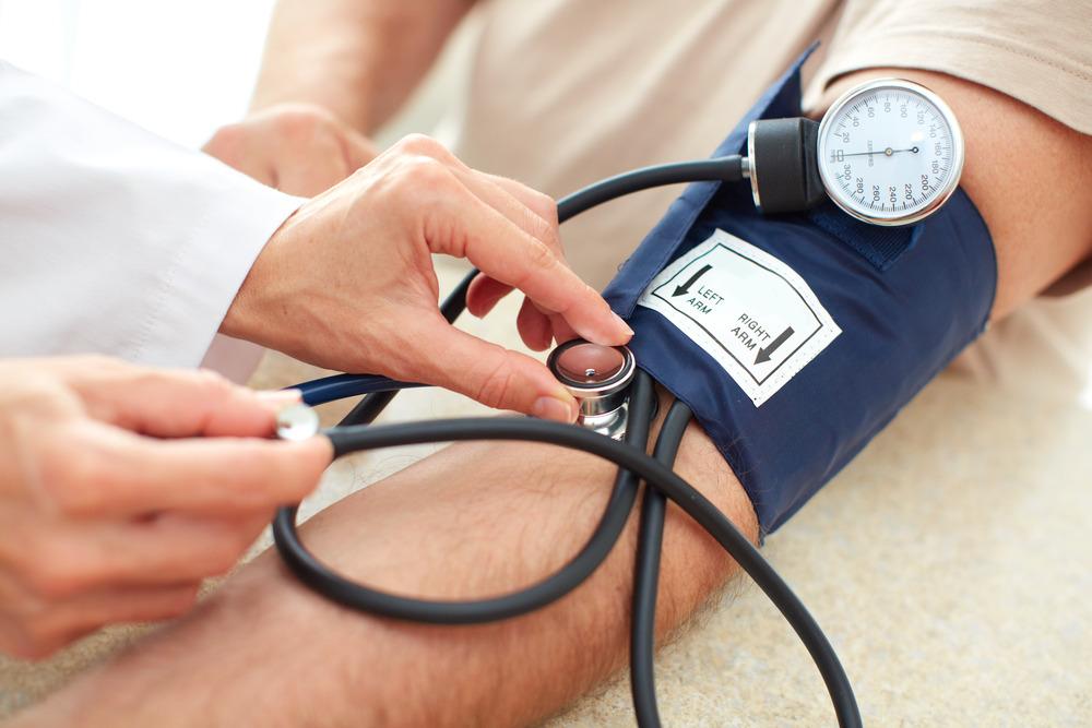 A person's blood pressure being taken with a pump.