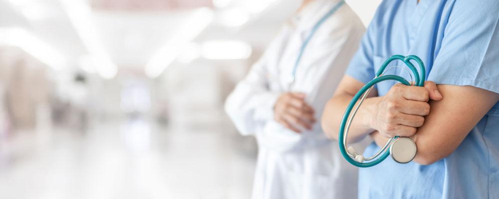 Two healthcare professionals in a hospital corridor.