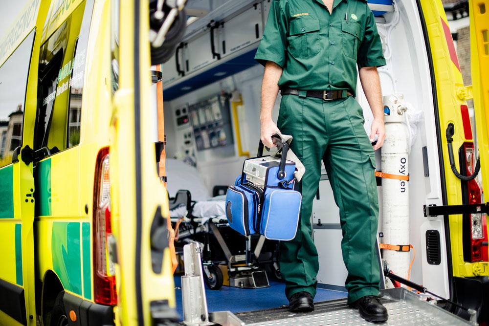 Paramedic stands at the entrance to an ambulance.