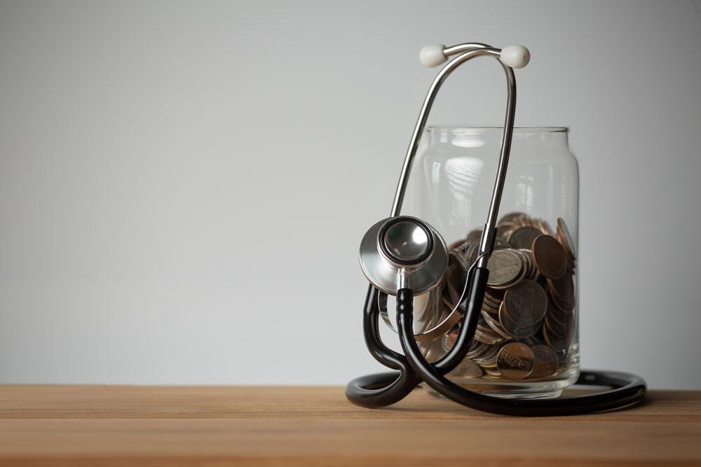 Stethoscope and coins in a glass jar.