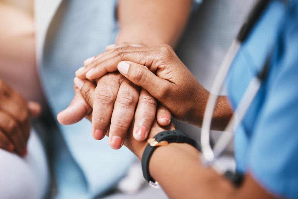 Nurse holding patient's hands