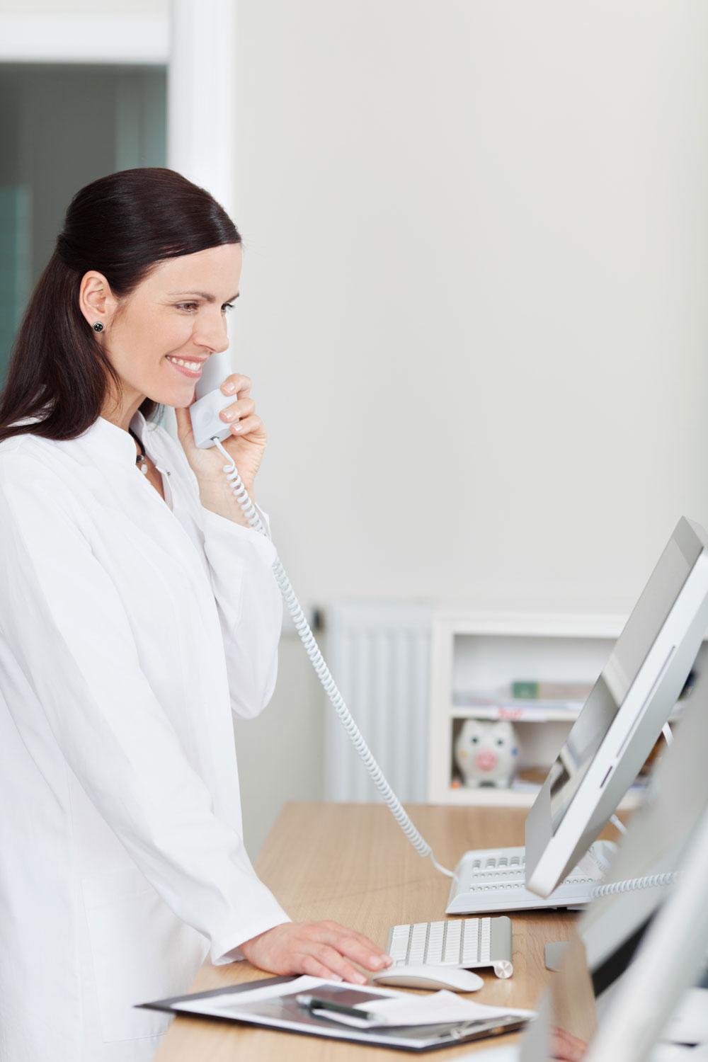 Doctor at computer on the phone