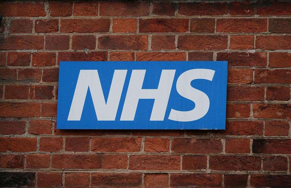NHS logo on brick wall