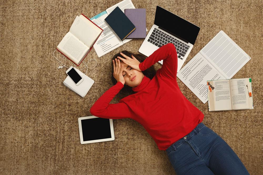 Girl stressed with books and laptop